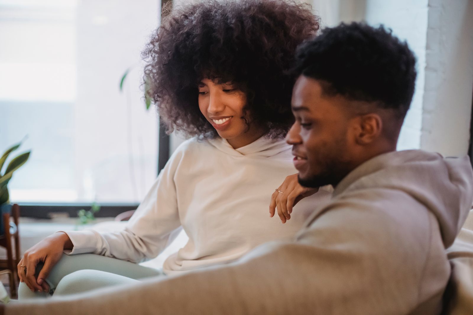 A couple at home, looking at something together