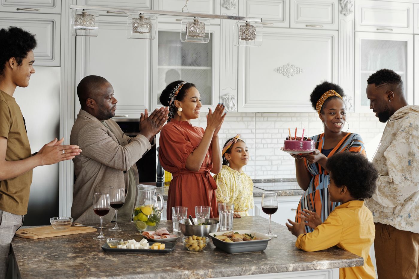 A family celebrating together in the kitchen at home
