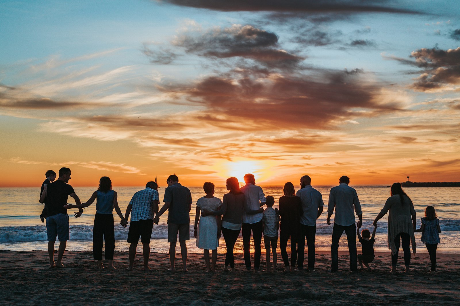 A family together on the shore at sunset