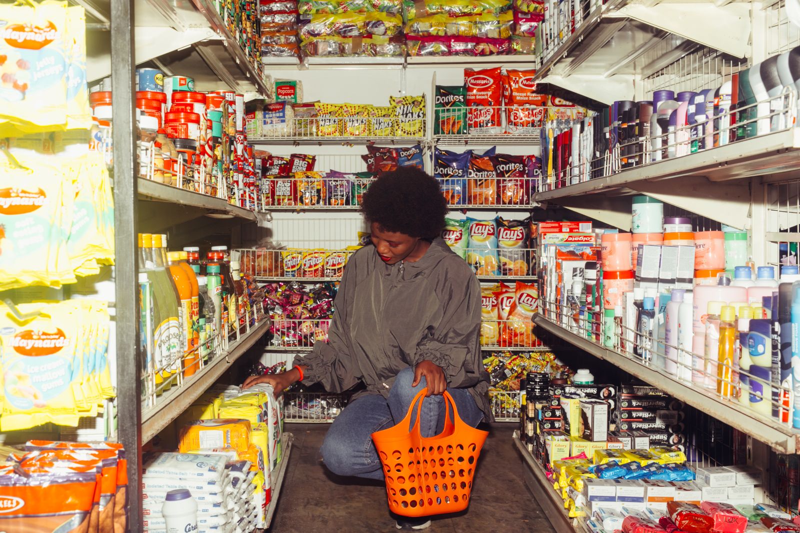 A shopper with a basket in a grocery aisle