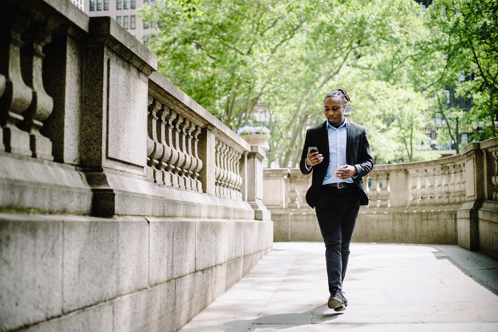 A young professional walking in the city with a phone